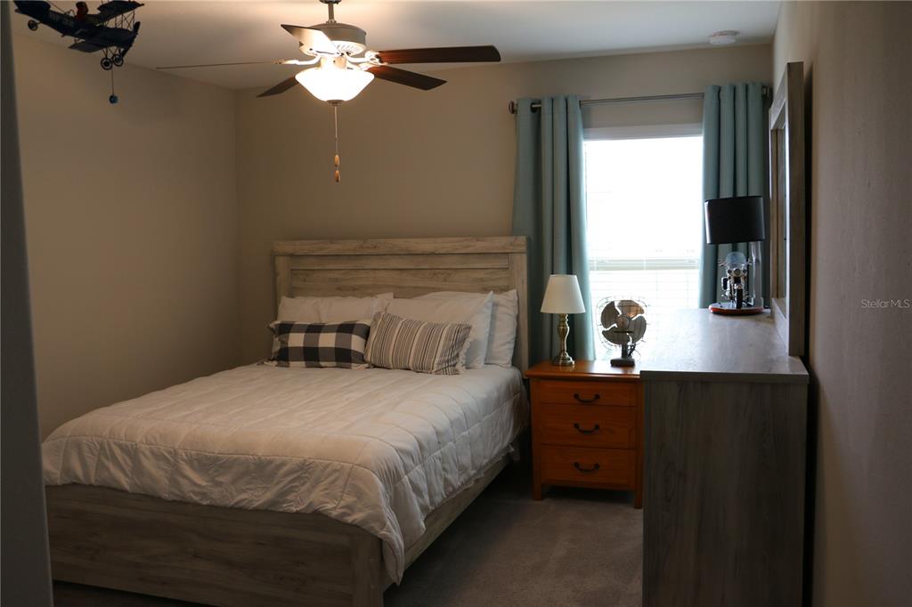 16554 Delia Street Wimauma, FL 33598 - Photo 22 of 44 a bedroom with a bed and a chandelier