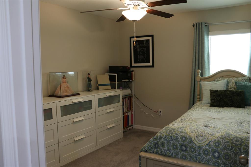 16554 Delia Street Wimauma, FL 33598 - Photo 24 of 44 a bedroom with a bed and a chandelier