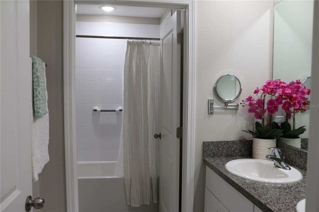 16554 Delia Street Wimauma, FL 33598 - Photo 28 of 44 a bathroom with a granite countertop shower sink vanity mirror and vanity