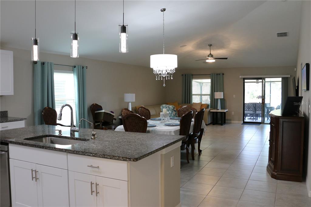 16554 Delia Street Wimauma, FL 33598 - Photo 10 of 44 a kitchen with center island table and chairs in it