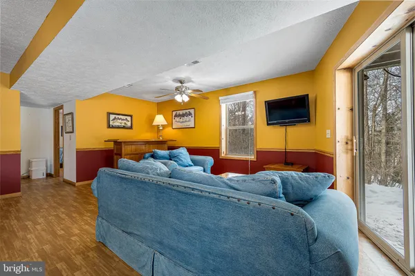 a living room with furniture a flat screen tv and a window