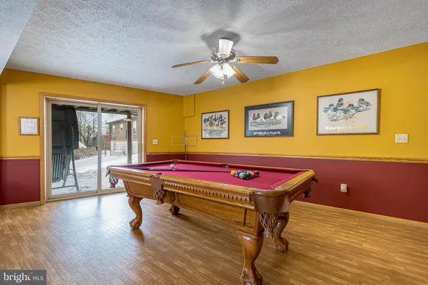 a room with pool table and windows