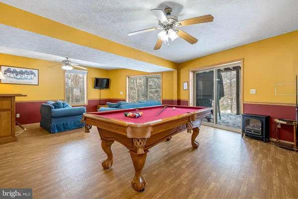 a room with pool table and wooden floor