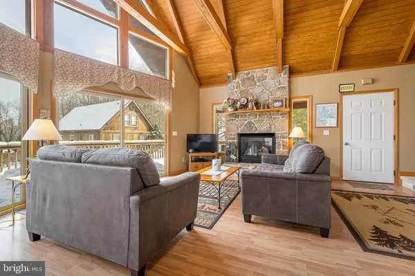 a living room with furniture a fireplace and a large window