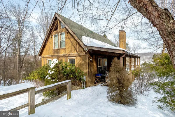 a view of a house with a tree and wooden fence
