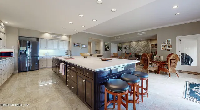 a kitchen with stainless steel appliances a table chairs stove and refrigerator