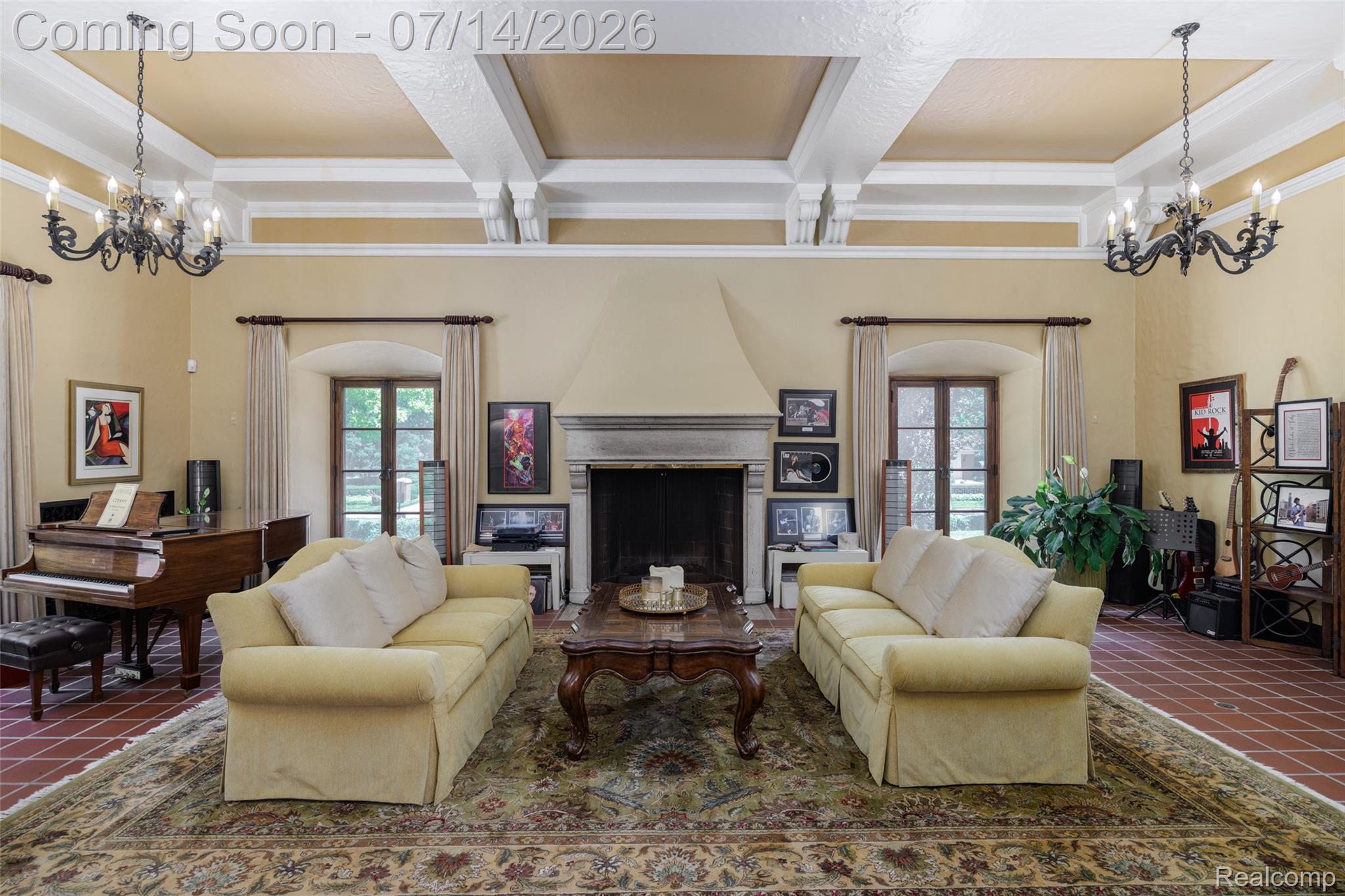 189 Cloverly Road Grosse Pointe, MI 48236 - Photo 13 of 96 Spacious living area featuring a prominent fireplace with stone surround, wood-finish flooring, coffered ceiling, and two ornate chandeliers
