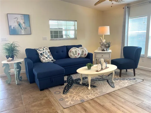 a living room with furniture a flat screen tv and a potted plant