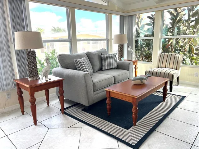a living room with furniture and a floor to ceiling window