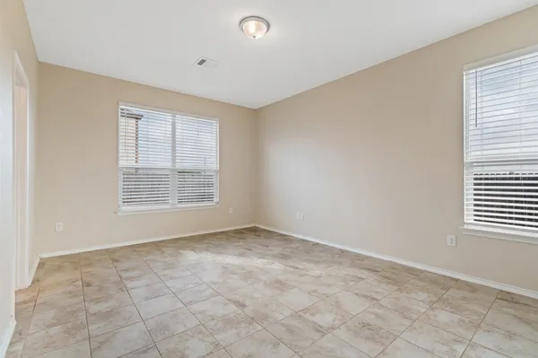 an empty room with windows and fireplace