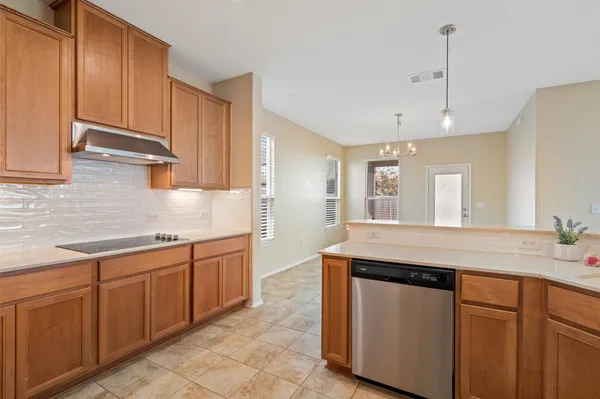 a kitchen with stainless steel appliances granite countertop a sink and dishwasher a stove with wooden cabinets