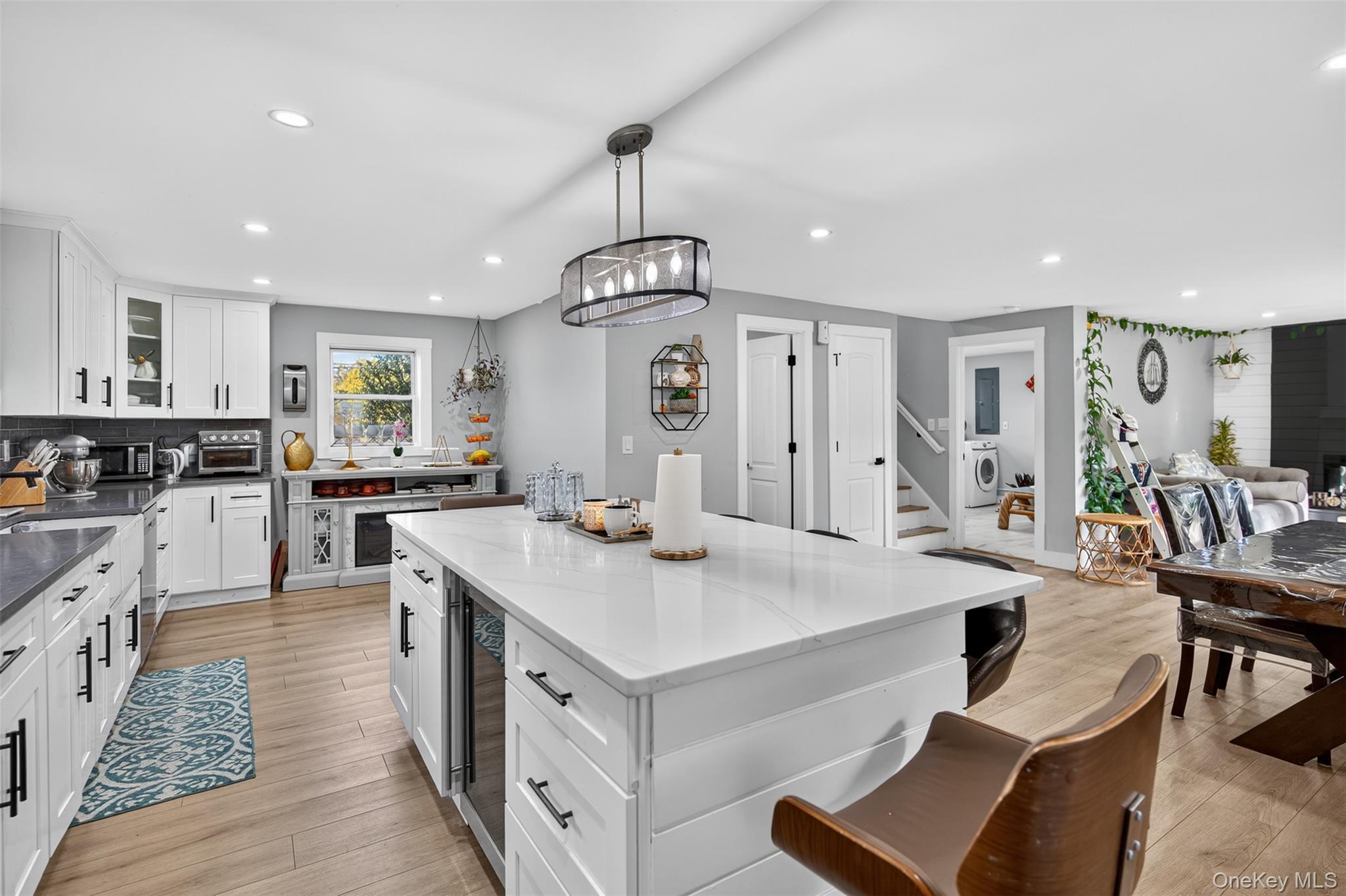 88 Spackenkill Road Poughkeepsie, NY 12603 - Photo 10 of 22 a open kitchen with stainless steel appliances kitchen island a stove a sink dishwasher and white cabinets with wooden floor