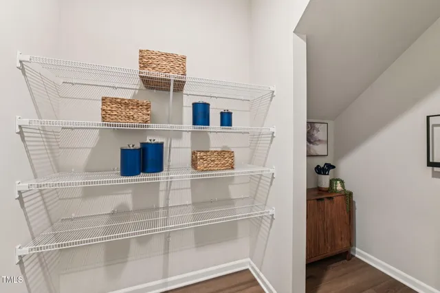 a kitchen with stainless steel appliances kitchen island granite countertop a stove a sink a refrigerator and white cabinets with wooden floor