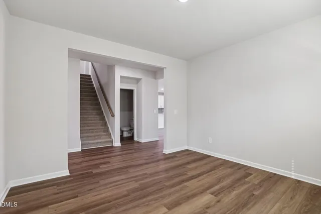an empty room with wooden floor and window