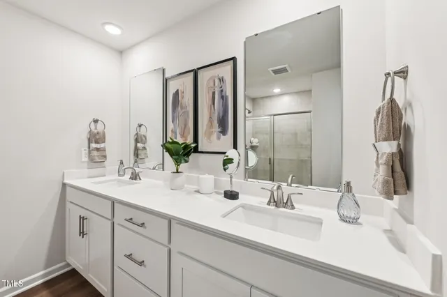 a bathroom with double vanity sinks and a mirror