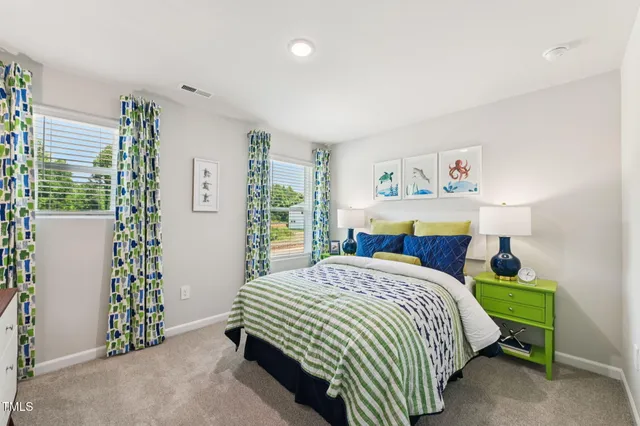 a bedroom with a bed and a lamp on dresser