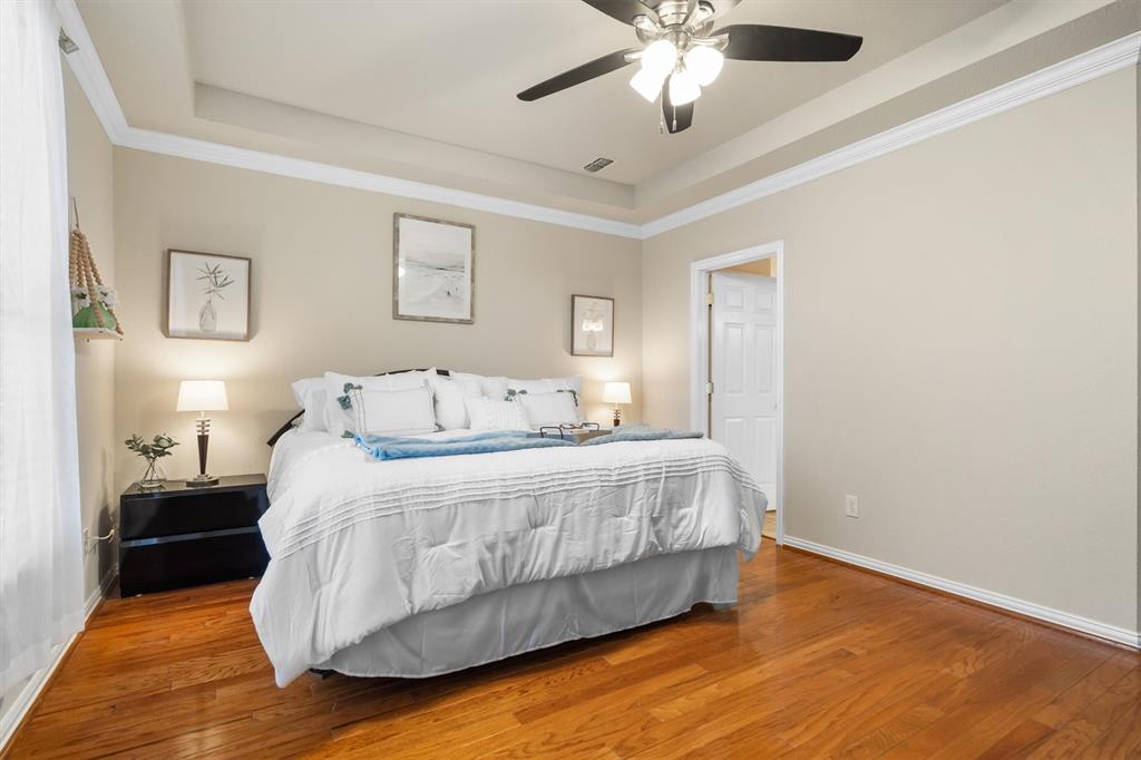 1017 Tanglewood Lane Flower Mound, TX 75028 - Photo 20 of 38 Natural light enhances the calm, welcoming feel of this generous bedroom space.