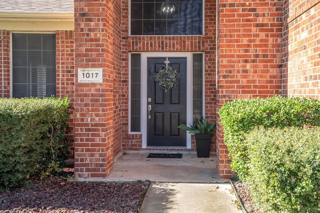 1017 Tanglewood Lane Flower Mound, TX 75028 - Photo 3 of 38 A welcoming front porch framed by neatly maintained landscaping creates a clean, polished, and inviting first impression.