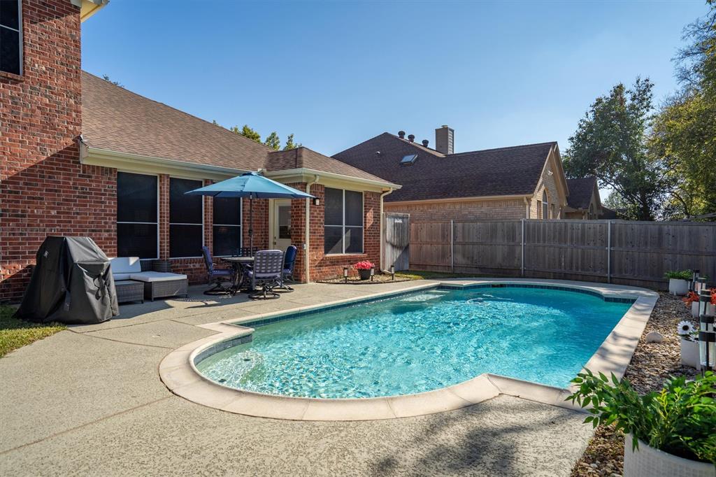 1017 Tanglewood Lane Flower Mound, TX 75028 - Photo 31 of 38 This inviting outdoor space is ideal for lounging, swimming, and creating summer memories.
