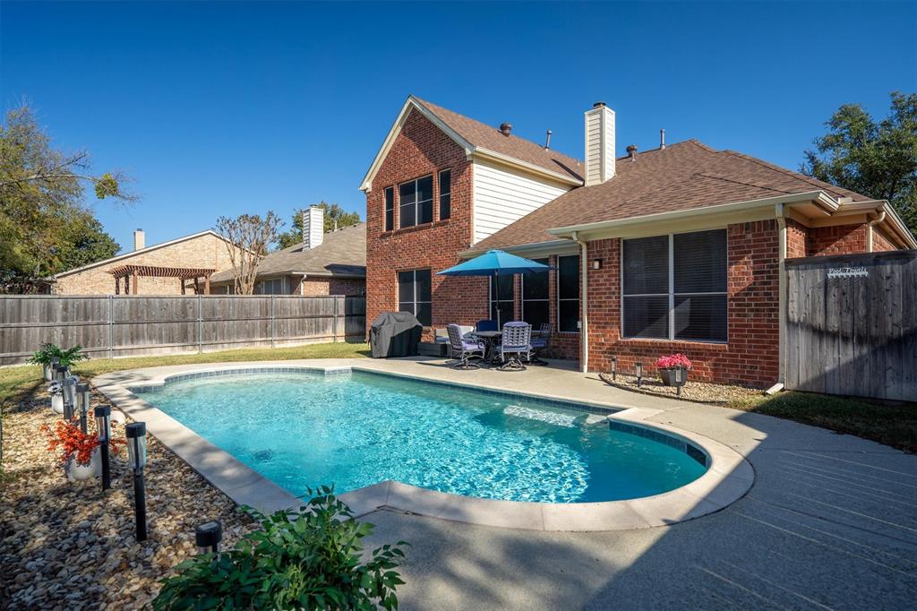 1017 Tanglewood Lane Flower Mound, TX 75028 - Photo 32 of 38 A beautiful view of the pool highlights how much room you have to relax, entertain, and enjoy the outdoors.