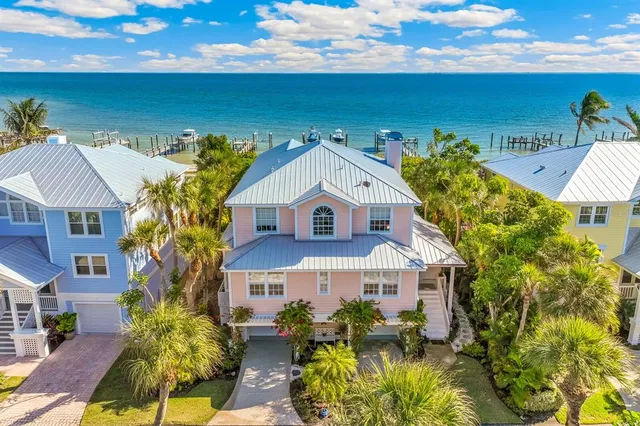 a aerial view of a house with a big yard and large tree
