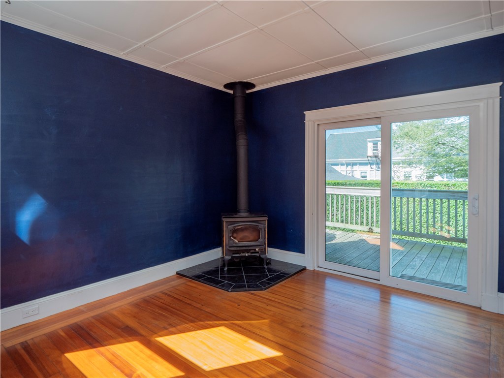 573 Spring Street Newport, RI 02840 - Photo 21 of 50 Back Sitting room off dining area with wood stove and sliders to back deck