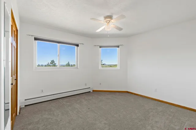 an empty room with fan and windows
