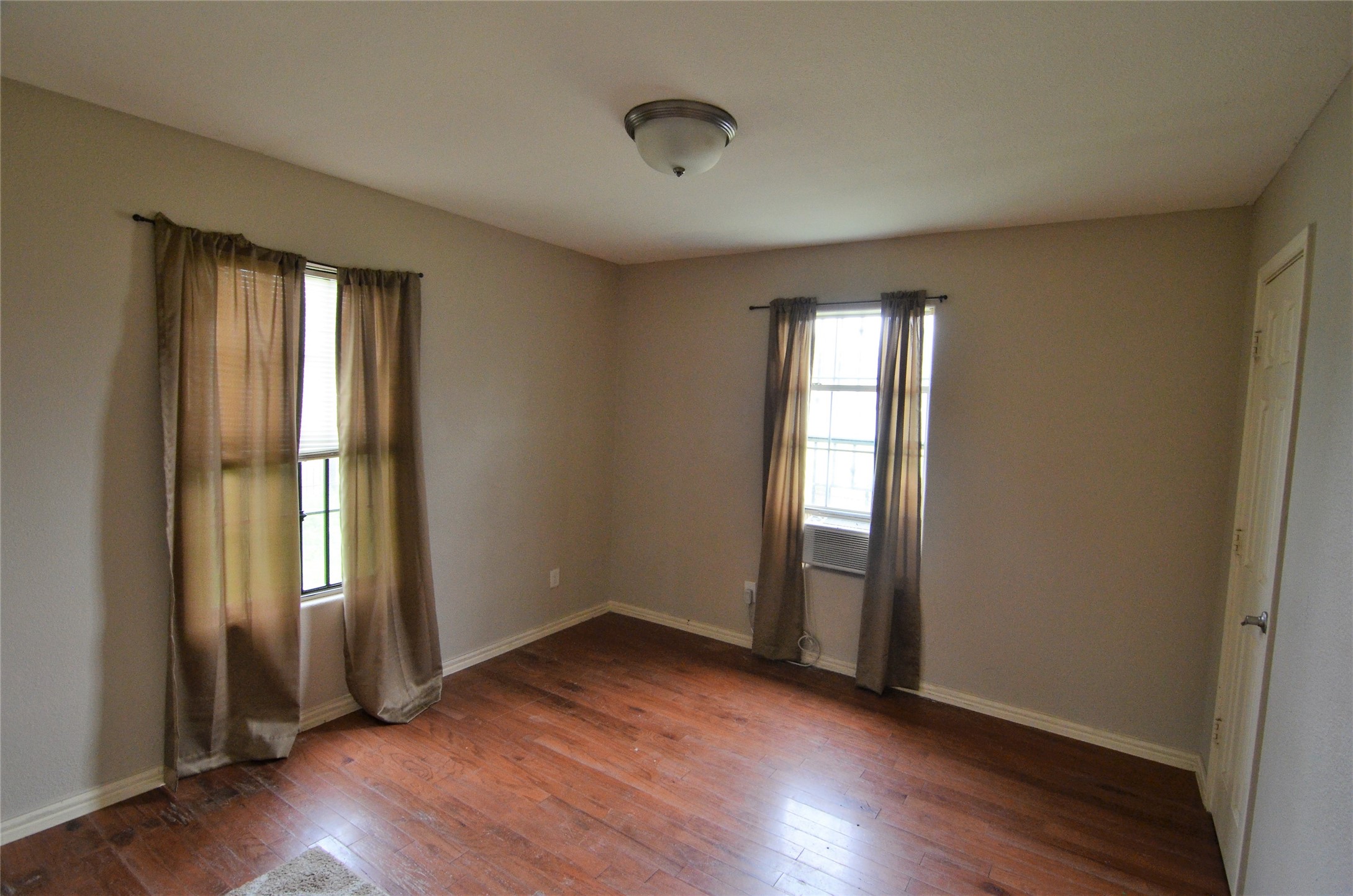 7326 Eagle Pass Street Houston, TX 77020 - Photo 13 of 26 an empty room with wooden floor and windows