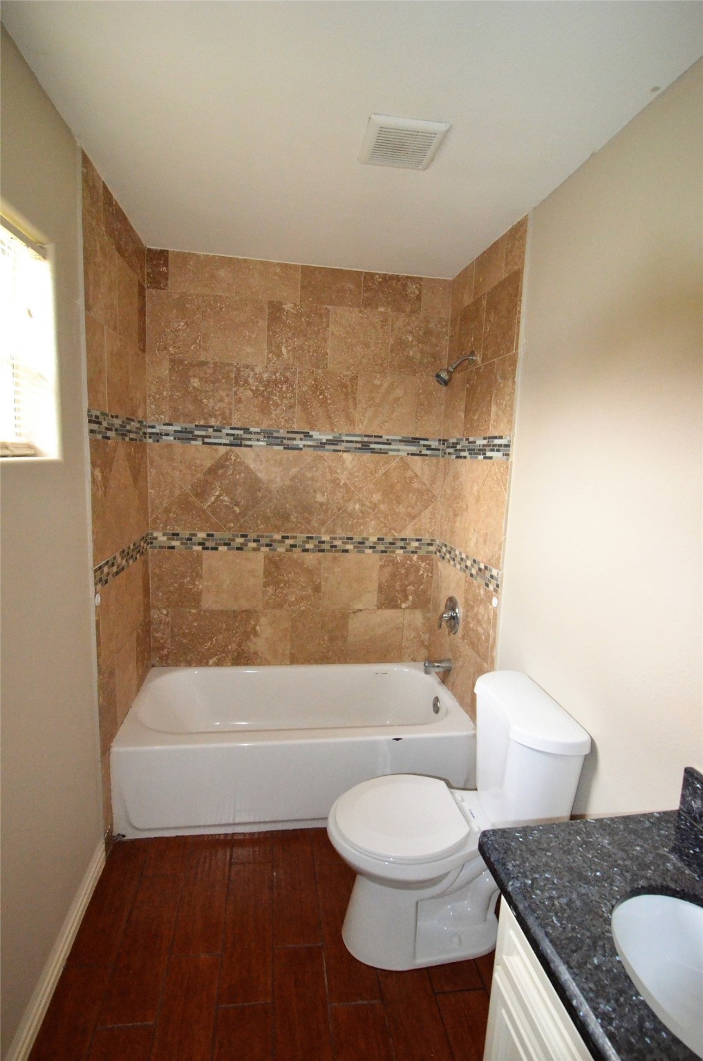 7326 Eagle Pass Street Houston, TX 77020 - Photo 14 of 26 a bathroom with a granite countertop toilet a sink and bathtub