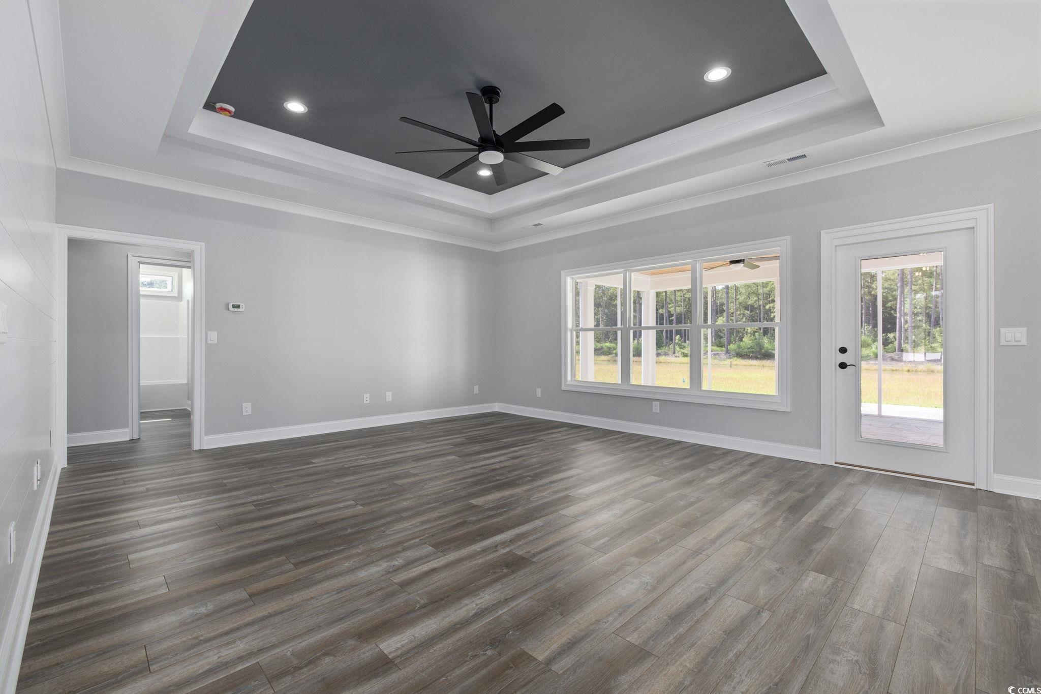6922 Pauley Swamp Road Conway, SC 29527 - Photo 11 of 40 Spare room featuring ceiling fan, dark wood-style flooring, crown molding, a raised ceiling, and recessed lighting