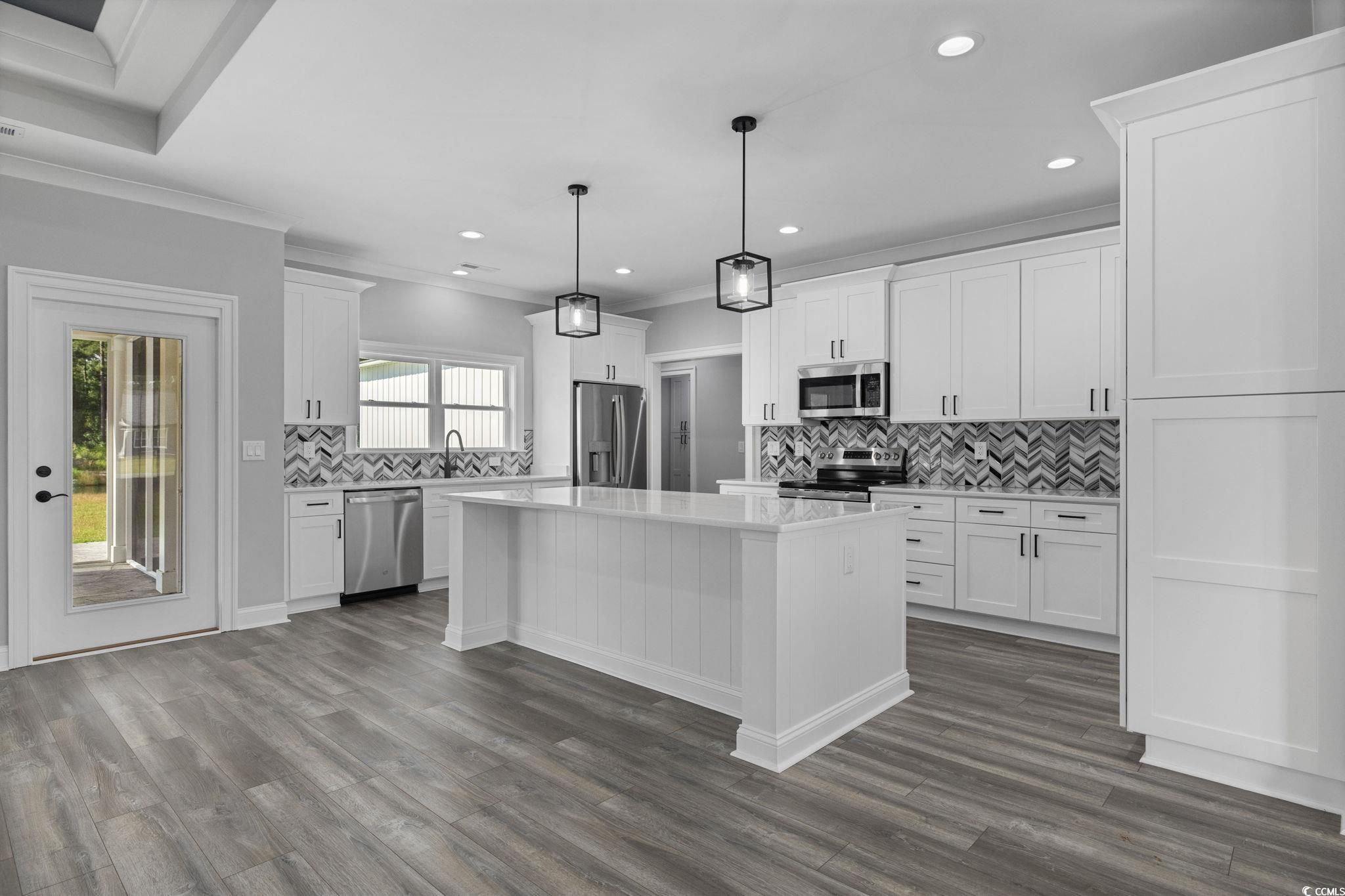 6922 Pauley Swamp Road Conway, SC 29527 - Photo 14 of 40 Kitchen with backsplash, white cabinetry, decorative light fixtures, healthy amount of natural light, and crown molding