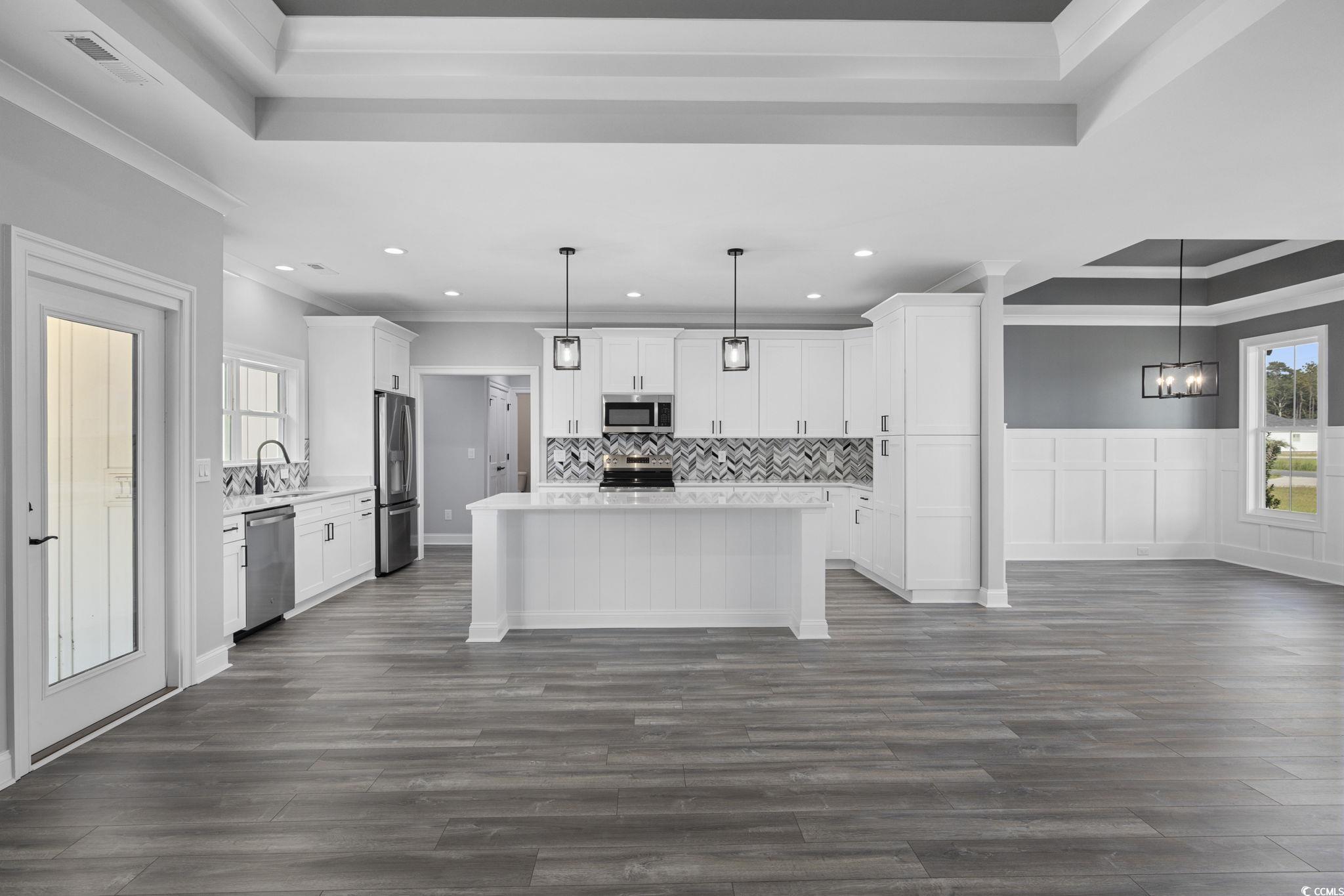 6922 Pauley Swamp Road Conway, SC 29527 - Photo 15 of 40 Kitchen with a tray ceiling, plenty of natural light, white cabinetry, crown molding, and recessed lighting