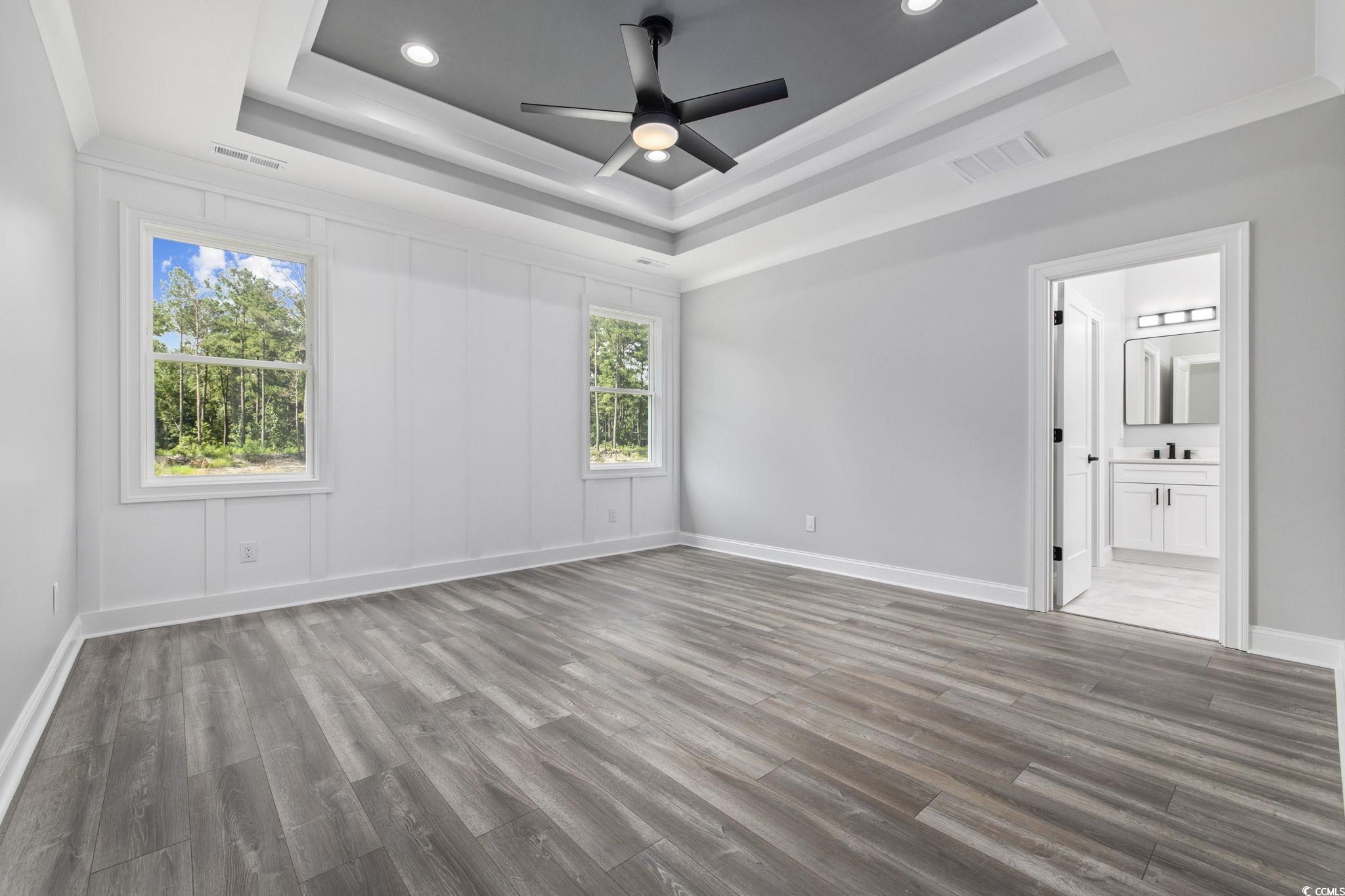 6922 Pauley Swamp Road Conway, SC 29527 - Photo 16 of 40 Unfurnished bedroom with wood finished floors, ornamental molding, a ceiling fan, recessed lighting, and a tray ceiling