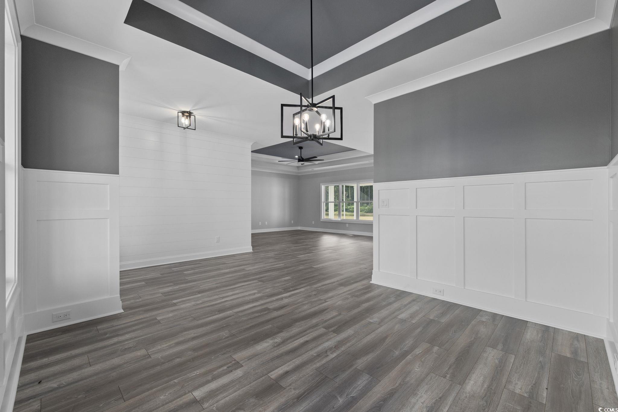6922 Pauley Swamp Road Conway, SC 29527 - Photo 22 of 40 Unfurnished dining area featuring a raised ceiling, a decorative wall, dark wood-style floors, a wainscoted wall, and ceiling fan