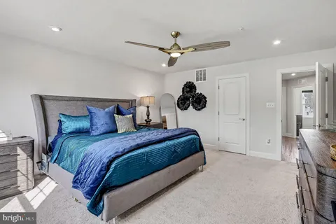 a spacious bedroom with a bed and a ceiling fan