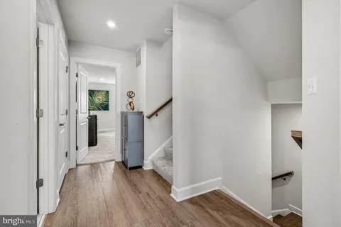 a view of a hallway with wooden floor and entryway