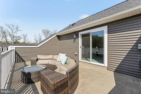 a view of a patio with couches chairs and wooden floor