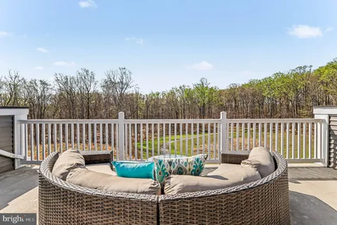a roof deck with couches and wooden fence