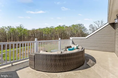 a roof deck with couches and wooden floor