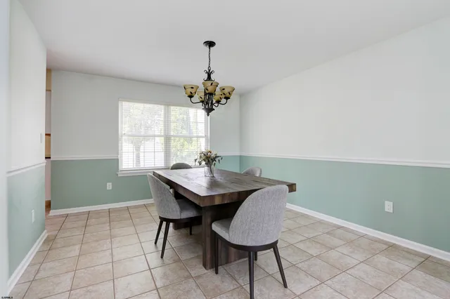 a large kitchen with a refrigerator a sink dishwasher a stove and white cabinets with wooden floor