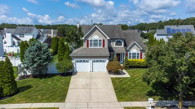 a front view of a house with a yard and potted plants