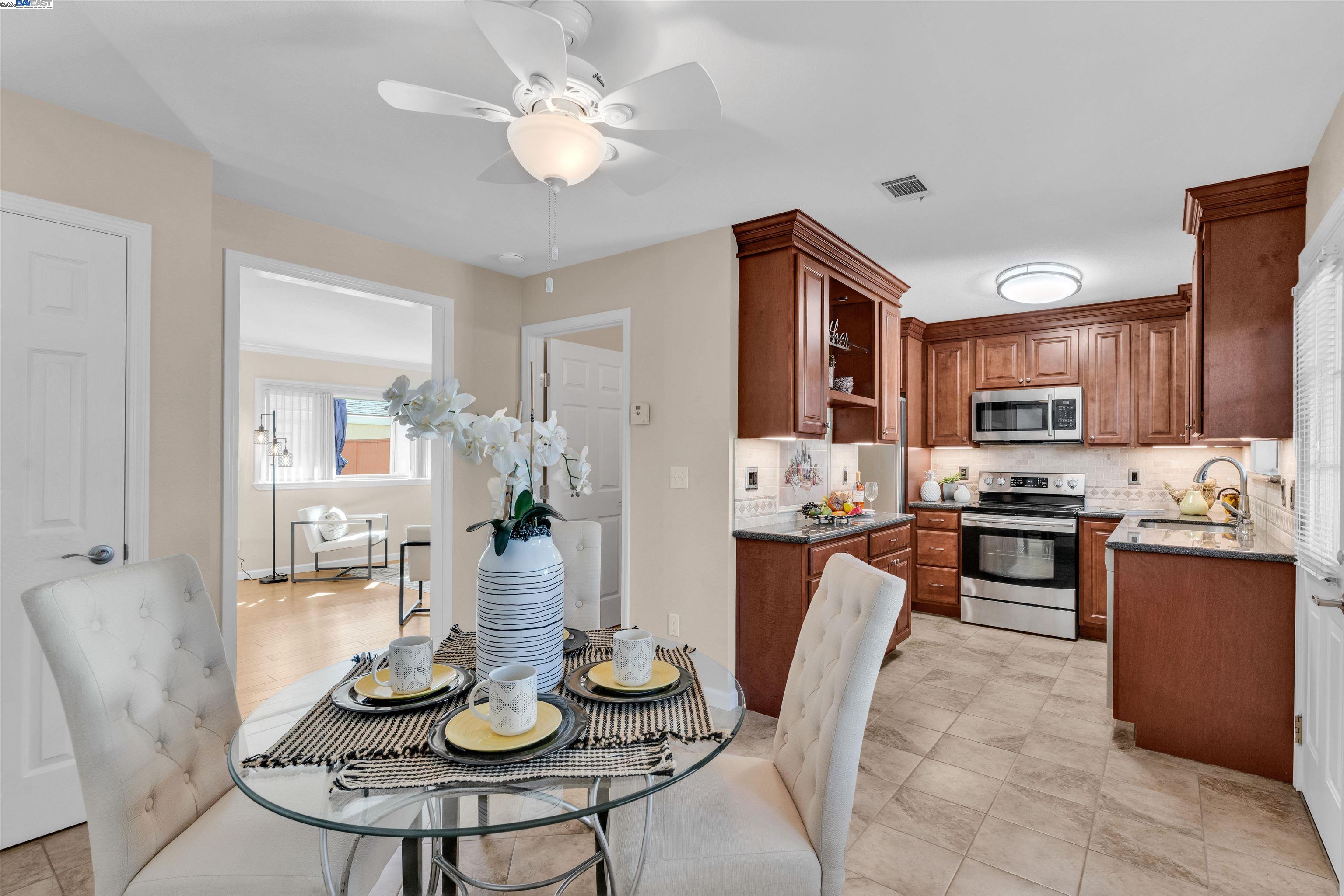 7602 Arbor Creek Circle Dublin, CA 94568 - Photo 14 of 47 a kitchen with stainless steel appliances kitchen island granite countertop a table chairs and a refrigerator