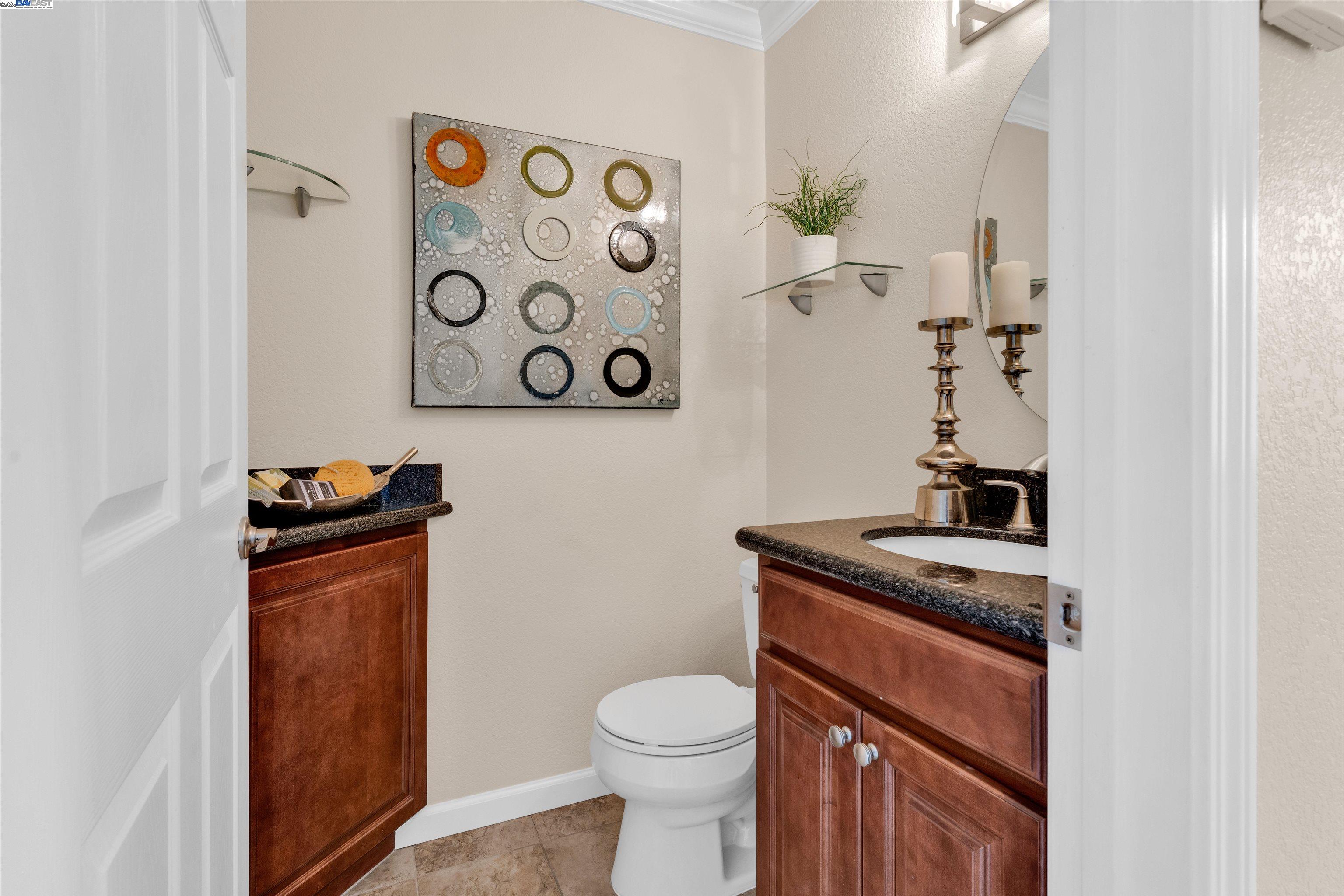 7602 Arbor Creek Circle Dublin, CA 94568 - Photo 21 of 47 a bathroom with a granite countertop toilet sink and mirror