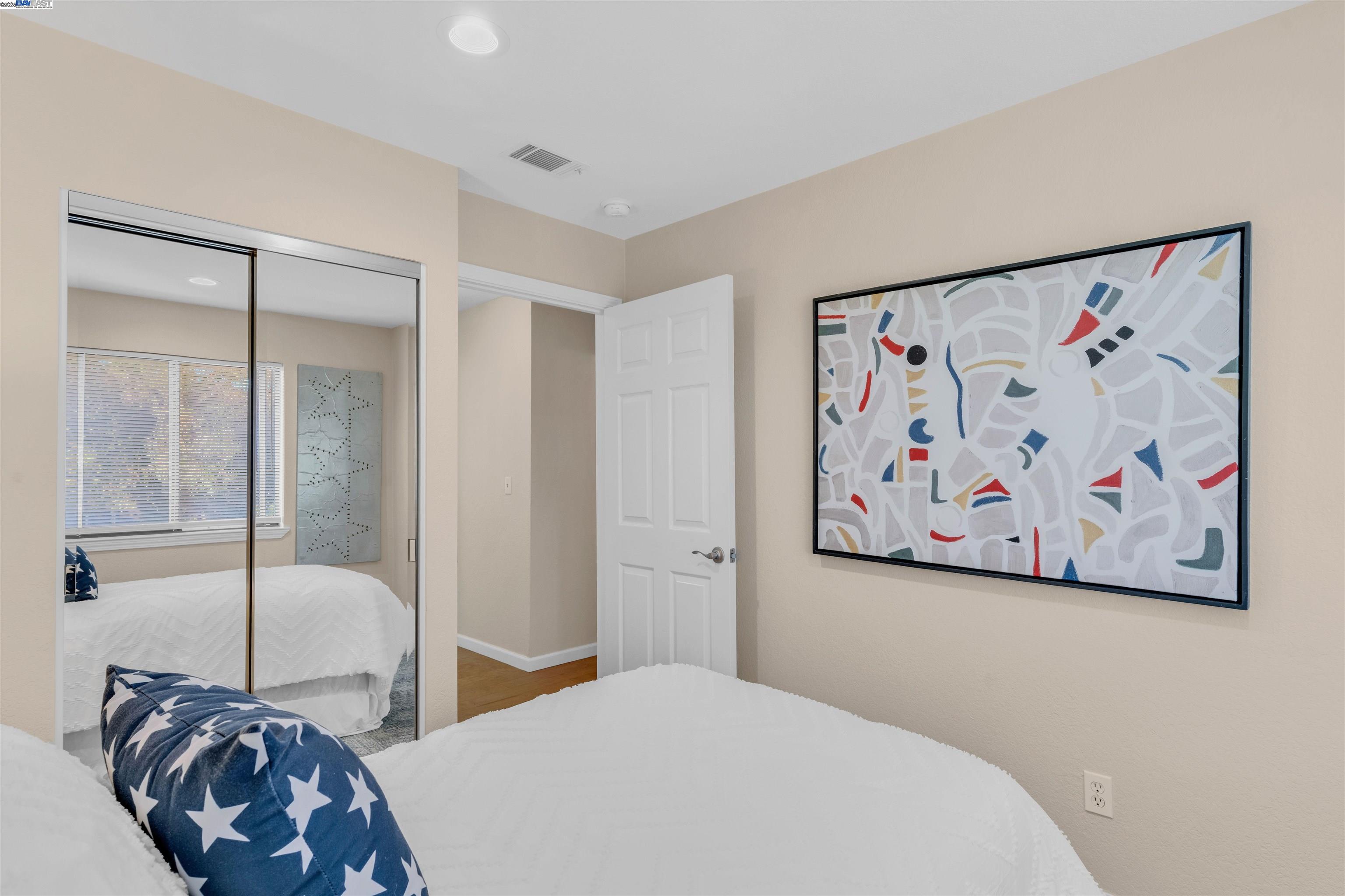 7602 Arbor Creek Circle Dublin, CA 94568 - Photo 30 of 47 a bedroom with a large bed and a painting on the wall