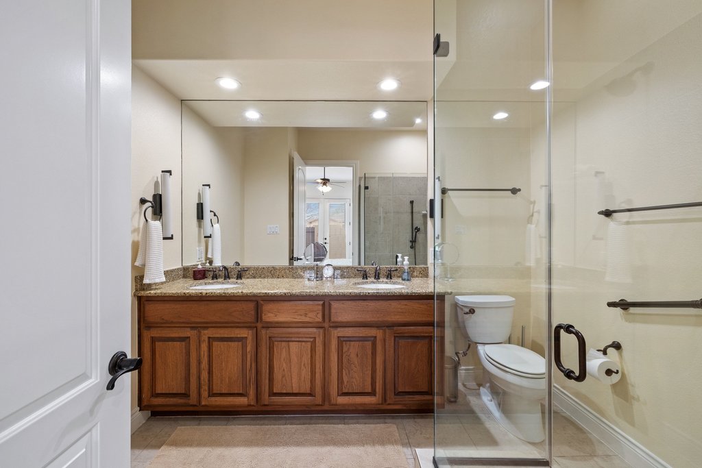 108-2 Rivalto Circle, Unit 2 Lakeway, TX 78734 - Photo 11 of 21 a bathroom with a granite countertop toilet sink and mirror