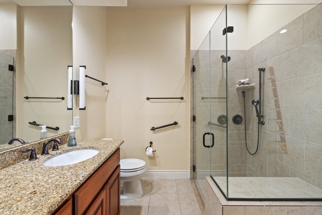 108-2 Rivalto Circle, Unit 2 Lakeway, TX 78734 - Photo 13 of 21 a bathroom with a granite countertop sink a toilet and shower