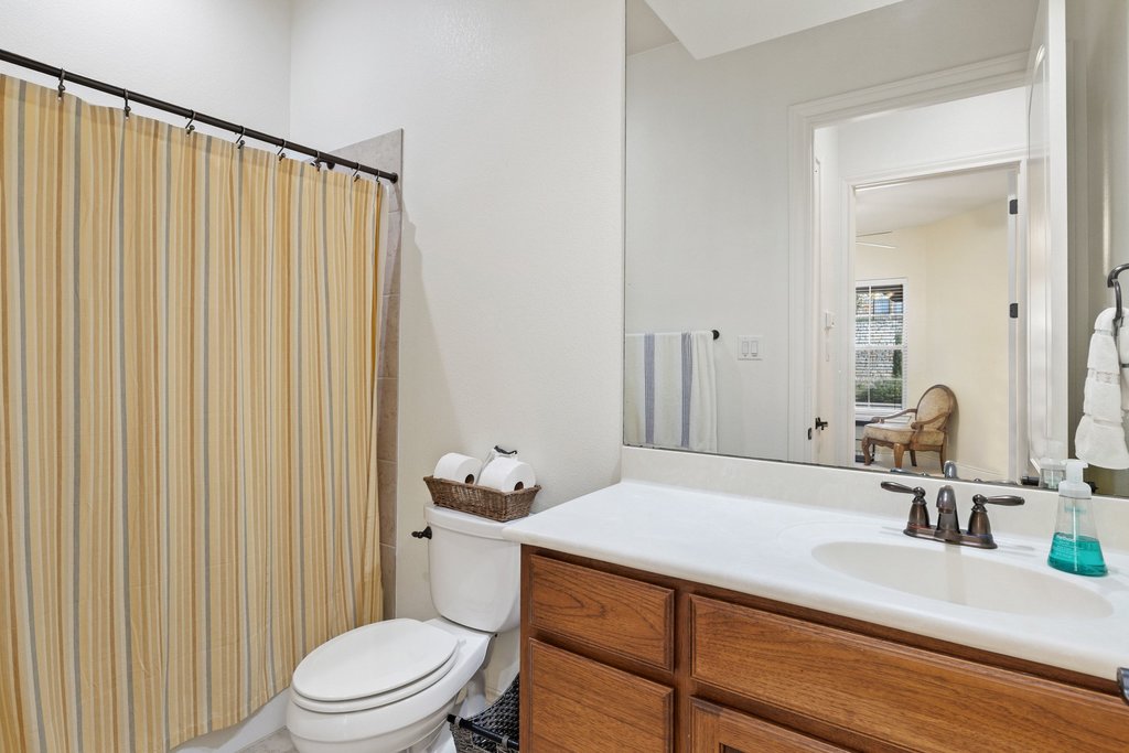 108-2 Rivalto Circle, Unit 2 Lakeway, TX 78734 - Photo 16 of 21 a bathroom with a sink a toilet and shower curtain