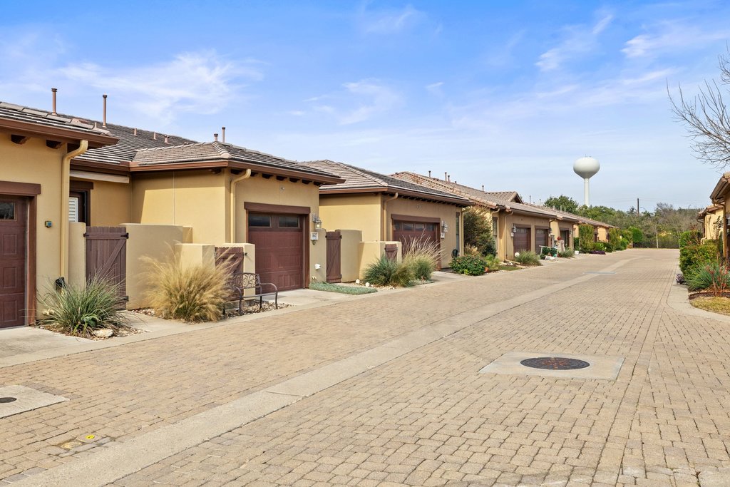 108-2 Rivalto Circle, Unit 2 Lakeway, TX 78734 - Photo 20 of 21 a yellow house with tree in front of it
