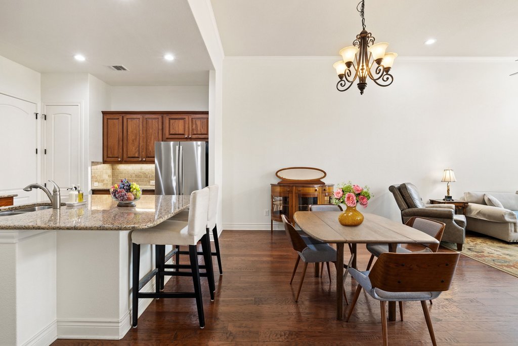 108-2 Rivalto Circle, Unit 2 Lakeway, TX 78734 - Photo 7 of 21 a view of a dining room with furniture wooden floor and chandelier