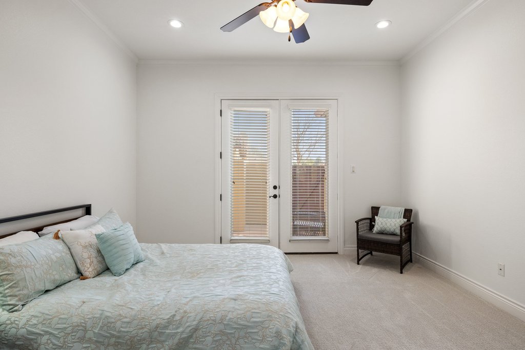 108-2 Rivalto Circle, Unit 2 Lakeway, TX 78734 - Photo 10 of 21 a bedroom with a bed and a chandelier